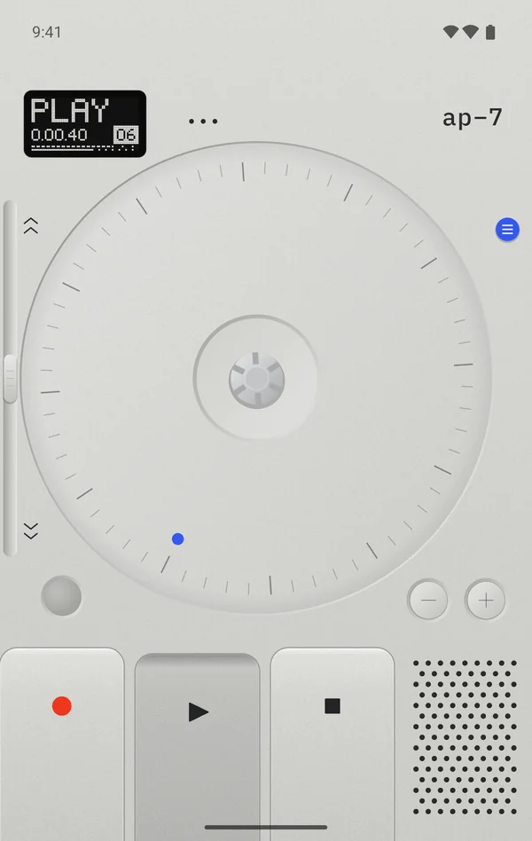 The AP-7 face in silver: the display reading PLAY 0.00.40, tape 06, the round blue M key on the right edge, the slider down the left edge with arrows at each end, the big reel, the grey record lamp bottom left, minus and plus keys bottom right, and the record, play and stop keys along the bottom with the play key held down.